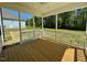 A screened porch has a wood floor, white railings, and a ceiling fan at 199 Grand Griffon Way, Lillington, NC 27546