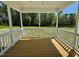 Outdoor screened porch with wood flooring and white railings, overlooking yard at 199 Grand Griffon Way, Lillington, NC 27546