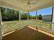 This screened porch has a wood floor, white railings, and a ceiling fan at 199 Grand Griffon Way, Lillington, NC 27546