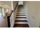 Beautiful staircase with wood treads, white risers, and a stained wood handrail provides access to upper level at 199 Grand Griffon Way, Lillington, NC 27546