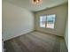 This bedroom features neutral carpeting, a large window and overhead lighting at 217 Grand Griffon Way, Lillington, NC 27546