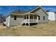 The back exterior features siding, a covered porch with white railing, and a backyard on a slight slope at 217 Grand Griffon Way, Lillington, NC 27546