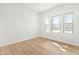 Empty bedroom featuring luxury vinyl plank floors and natural light from three windows at 313 Mason Oaks Dr, Wake Forest, NC 27587