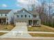 Charming two-story home with blue siding, a two-car garage, and a well-manicured front yard at 313 Mason Oaks Dr, Wake Forest, NC 27587