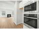 Stainless steel oven and microwave with living room and fireplace in background at 313 Mason Oaks Dr, Wake Forest, NC 27587
