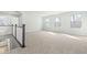 Bright and spacious carpeted loft area with natural light and railing overlooking the staircase at 313 Mason Oaks Dr, Wake Forest, NC 27587