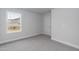 A simple bedroom features light grey carpet, white walls, and one window at 499 Glenkirk Pl # 101, Garner, NC 27529