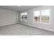 This bedroom features large windows, neutral walls, and plush carpet at 499 Glenkirk Pl # 101, Garner, NC 27529