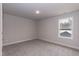 Spacious bedroom with grey carpet, light walls and one large window at 499 Glenkirk Pl # 101, Garner, NC 27529