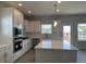White kitchen with stainless appliances, island, and bright natural light from multiple windows at 499 Glenkirk Pl # 101, Garner, NC 27529
