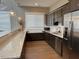 Spacious kitchen with dark wood cabinets, stainless steel appliances, and a white countertop with backsplash at 499 Glenkirk Pl # 101, Garner, NC 27529