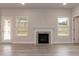 Bright living room featuring a fireplace with marble surround and two windows overlooking the backyard at 499 Glenkirk Pl # 101, Garner, NC 27529