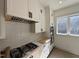 Close up of modern kitchen with white cabinets, stainless steel appliances, and gas cooktop at 704 Chatham View Rd # 12, Cary, NC 27511