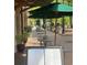 Outdoor cafe seating with green umbrellas over tables, set on a brick patio near green trees at 704 Chatham View Rd # 12, Cary, NC 27511