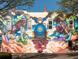 A vibrant mural adorns the side of a brick building, showing colorful characters and a blue engine at 704 Chatham View Rd # 12, Cary, NC 27511