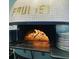 A tiled pizza oven with flames inside, ready to cook delicious pizzas in a restaurant setting at 704 Chatham View Rd # 12, Cary, NC 27511