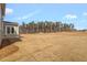 Expansive backyard featuring dormant grass, a line of trees in the distance, and new home construction at 1125 Brookfield Dr, Gibsonville, NC 27249