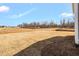 Expansive backyard featuring dormant grass and new home construction site in the distance at 1125 Brookfield Dr, Gibsonville, NC 27249