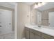 A clean, bright bathroom features a single sink with a large mirror and gray cabinets at 1125 Brookfield Dr, Gibsonville, NC 27249
