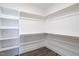 Walk-in closet with custom shelving, dark wood flooring, and white walls at 1125 Brookfield Dr, Gibsonville, NC 27249