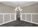 This is a spacious dining room featuring contemporary lighting, wood floors, and wainscoting details at 1125 Brookfield Dr, Gibsonville, NC 27249