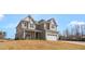 Beautiful two-story home with a classic design, showcasing a welcoming front porch and two-car garage at 1125 Brookfield Dr, Gibsonville, NC 27249
