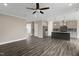 Open-concept living room with dark wood flooring and view of kitchen with granite countertop island at 1125 Brookfield Dr, Gibsonville, NC 27249