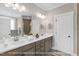 Bright bathroom with double vanity, large mirror, and modern fixtures at 1129 Brookfield Dr, Gibsonville, NC 27249