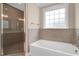 Beautiful bathroom showcasing a glass enclosed shower and a soaking tub under a window at 1129 Brookfield Dr, Gibsonville, NC 27249