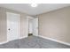 A bedroom has neutral walls, carpeted floors, with doors leading to closets and bathrooms at 1129 Brookfield Dr, Gibsonville, NC 27249