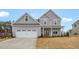 Charming two-story home with a two car garage, covered porch, and manicured lawn at 1129 Brookfield Dr, Gibsonville, NC 27249