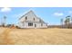 This exterior shows the backyard with a lawn that leads up to a gray two-story house at 1129 Brookfield Dr, Gibsonville, NC 27249