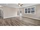 Bright living room with wood-look flooring, ceiling fan and large windows overlooking the outdoor space at 1129 Brookfield Dr, Gibsonville, NC 27249