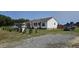 Well-maintained home with a large front yard, mature landscaping, and a gravel driveway at 3027 Nc Highway 210, Smithfield, NC 27577