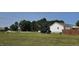 Expansive green lawn surrounding the home with mature trees and a gravel driveway at 3027 Nc Highway 210, Smithfield, NC 27577