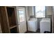 Bright laundry room featuring modern appliances, storage shelves, convenient exterior door, and ample natural light at 3027 Nc Highway 210, Smithfield, NC 27577