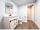 Updated bathroom featuring a modern vanity with a new toilet, mirror, and vinyl flooring at 3095 Woodsdale Rd, Roxboro, NC 27574