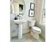 Charming powder room with a pedestal sink, decorative mirror, modern fixtures and a tiled floor at 2117 Opulent Oaks Ln # 15, Durham, NC 27713