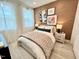 Cozy bedroom with wood-look accent wall, plush bedding, and modern nightstands at 2117 Opulent Oaks Ln # 15, Durham, NC 27713