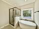 Modern bathroom with standalone tub, a glass shower and a window at 2613 Silver Gate Ct, Wake Forest, NC 27587