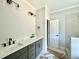 Bathroom features a double sink vanity with a gray-green base, modern fixtures, and tile floors at 2613 Silver Gate Ct, Wake Forest, NC 27587