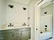 Bathroom with double sinks and gray cabinets next to a tub-shower combo at 2613 Silver Gate Ct, Wake Forest, NC 27587