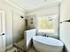Spa-like bathroom with freestanding tub, tiled shower, and stylish fixtures at 2613 Silver Gate Ct, Wake Forest, NC 27587