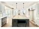 Open-concept kitchen featuring a large island, white cabinets, and a view into the living area at 2613 Silver Gate Ct, Wake Forest, NC 27587
