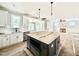 Open-concept kitchen featuring a large island, white cabinets, and a view into the living area at 2613 Silver Gate Ct, Wake Forest, NC 27587