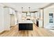 Bright kitchen features an island, modern stainless appliances, white cabinets, and hardwood floors at 2613 Silver Gate Ct, Wake Forest, NC 27587