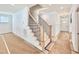 View of the stairway with wooden treads, black metal balusters and an entry door at 2617 Silver Gate Ct, Wake Forest, NC 27587