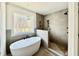 Modern bathroom featuring a soaking tub, walk-in shower, and stylish gray tile at 2621 Silver Gate Ct, Wake Forest, NC 27587