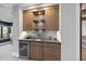Basement wet bar with wood cabinets and a stylish backsplash at 7640 Falls Creek Ln, Raleigh, NC 27614