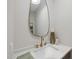 Elegant bathroom featuring a gold faucet and a teardrop mirror at 7640 Falls Creek Ln, Raleigh, NC 27614